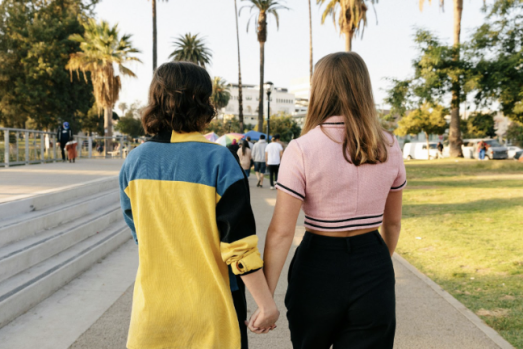 LGBTQ+ couple holding hands and smiling during a counseling session.