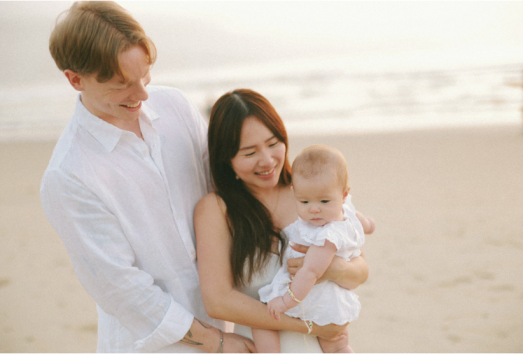 Couple sitting together with newborn, representing postpartum intimacy and reconnecting after birth