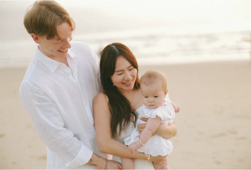 Couple sitting together with newborn, representing postpartum intimacy and reconnecting after birth